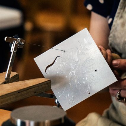 metal6 A piercing saw cuts a shape from a silver square.
