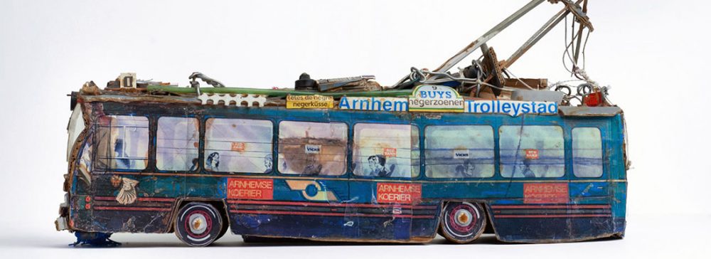 A small model of a tram made out of found materials such as cardboard packaging.