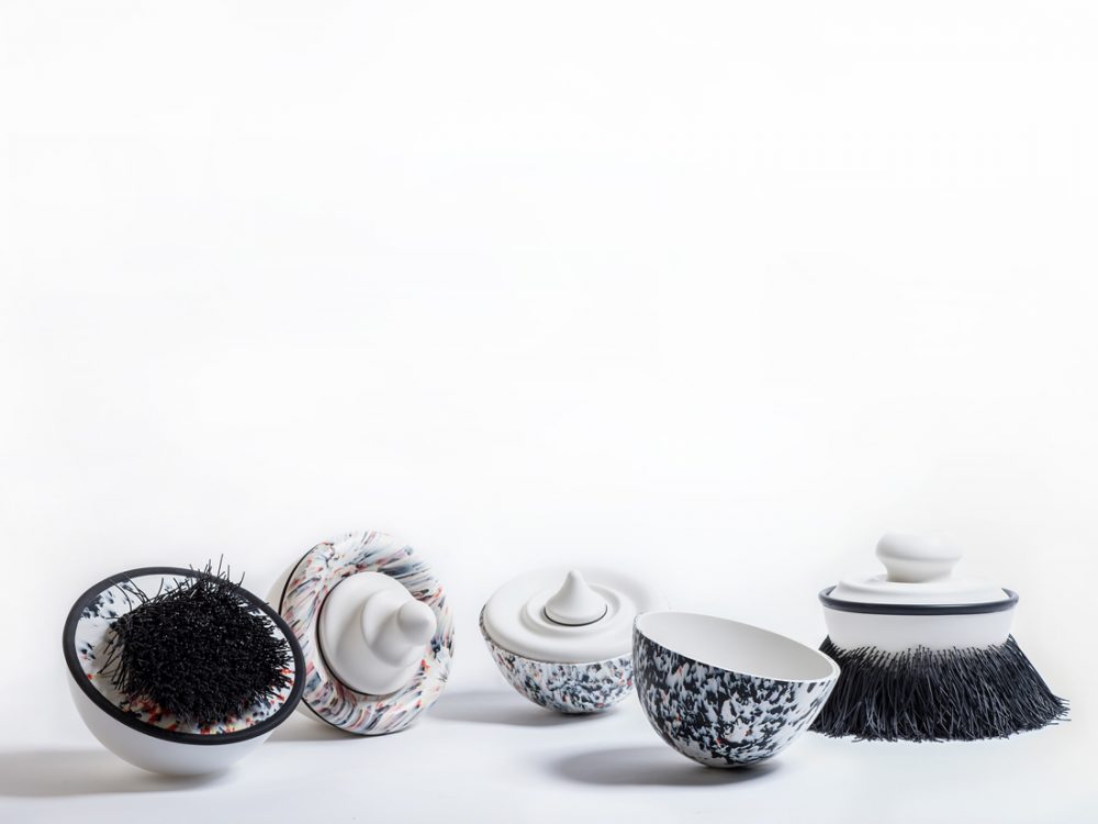 A group of small simple items made from a smooth, hard material. Cup-like forms with decoratoins like brushes and small knobs. Some are reminiscent of shaving brushes.