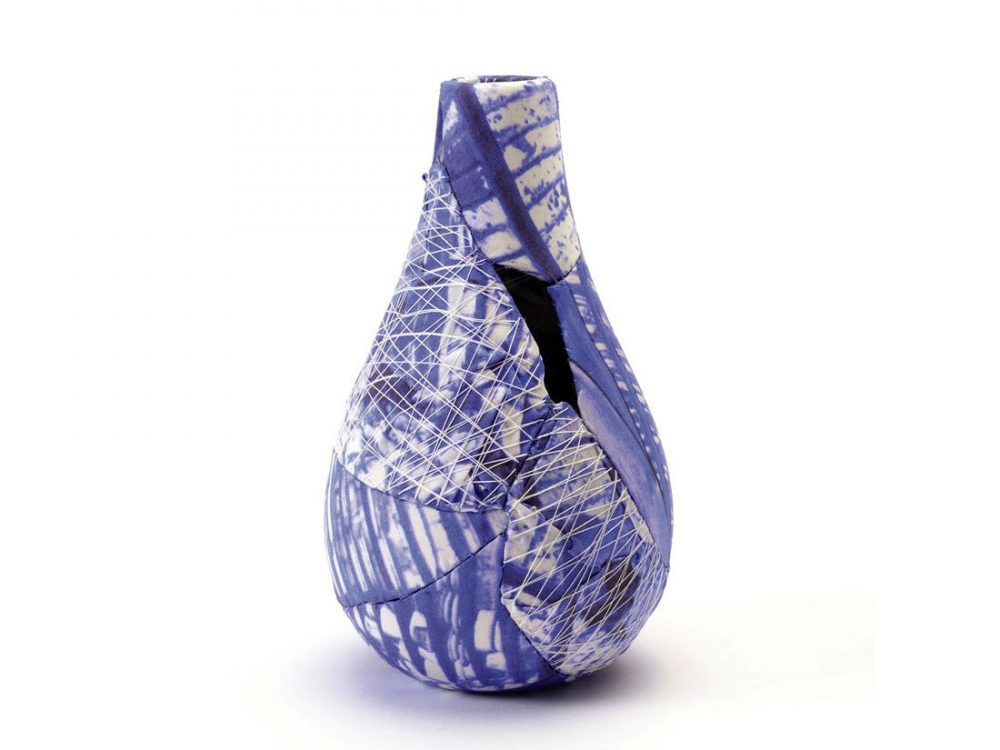 A small vase: broken pieces are covered in decorative fabric and stitched back together in the original shape.
