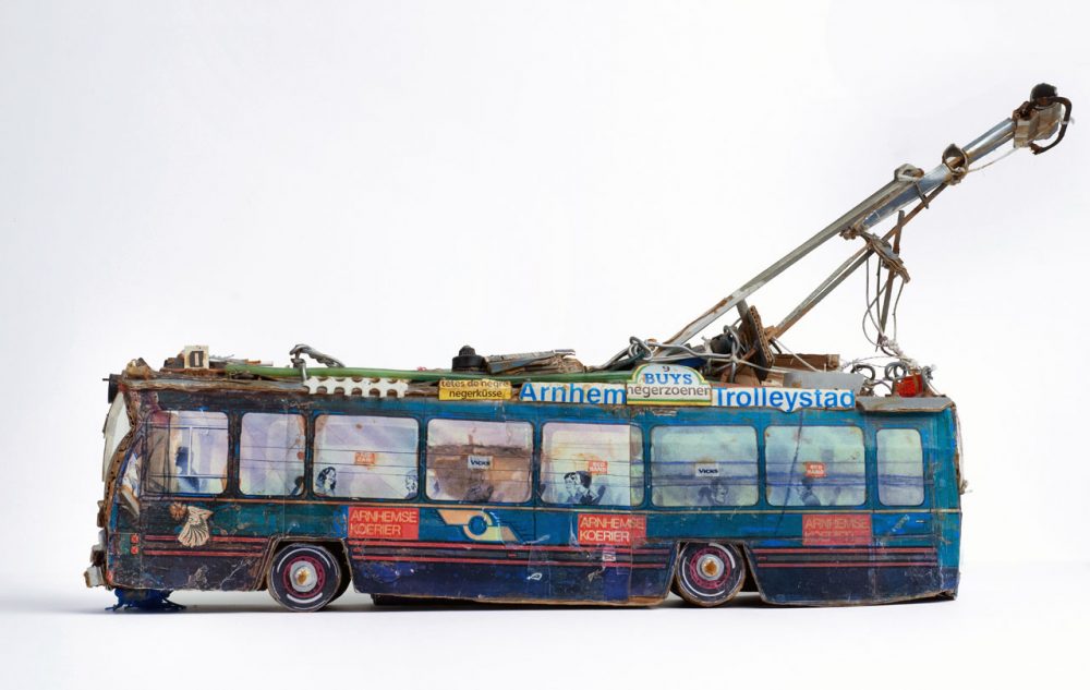 A small model of a tram made out of found materials such as cardboard packaging.