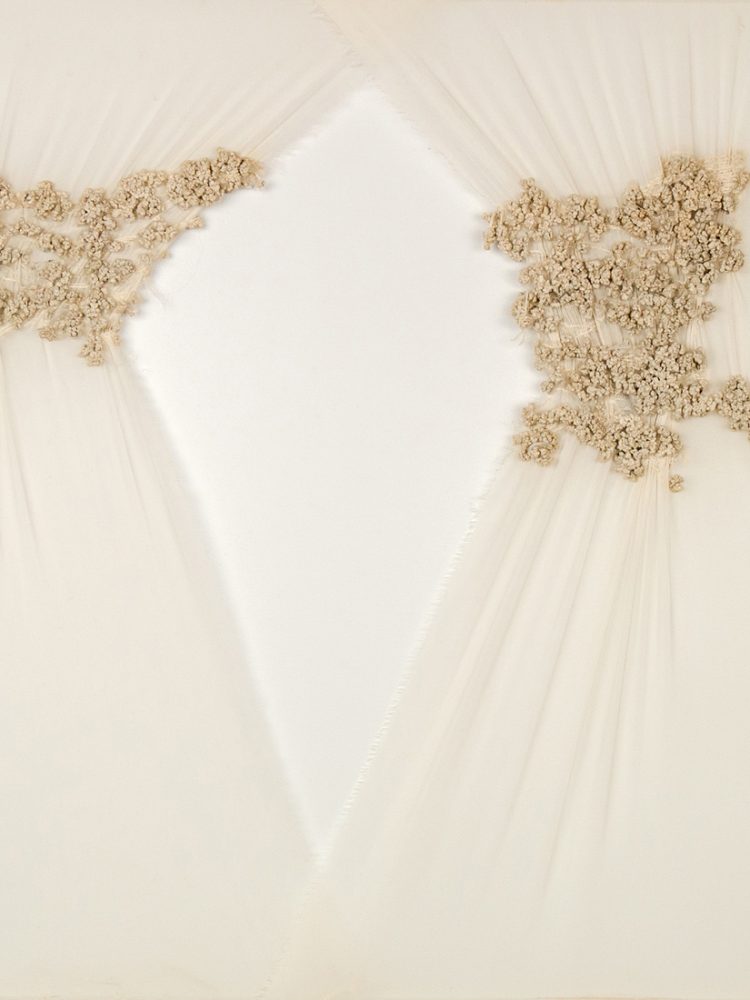 Sheets of cream material delicately draped, with cream coloured thread embroidered on to the surface.