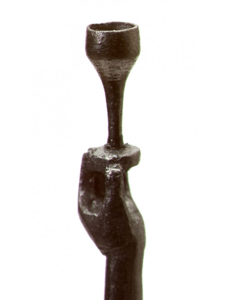 A close up of a small metal hand holding a cup.