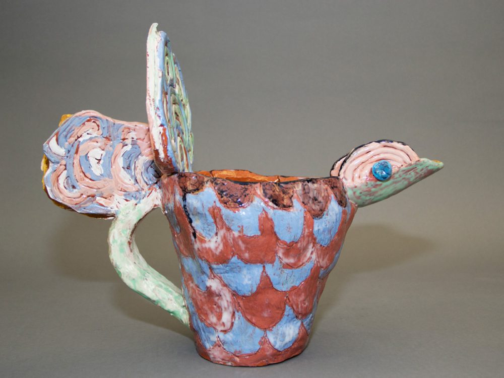 A colourful ceramic jug built to look like a bird.