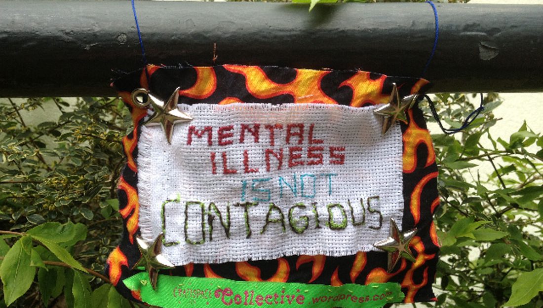 A small textile sign with metal stars with a message about mental health.