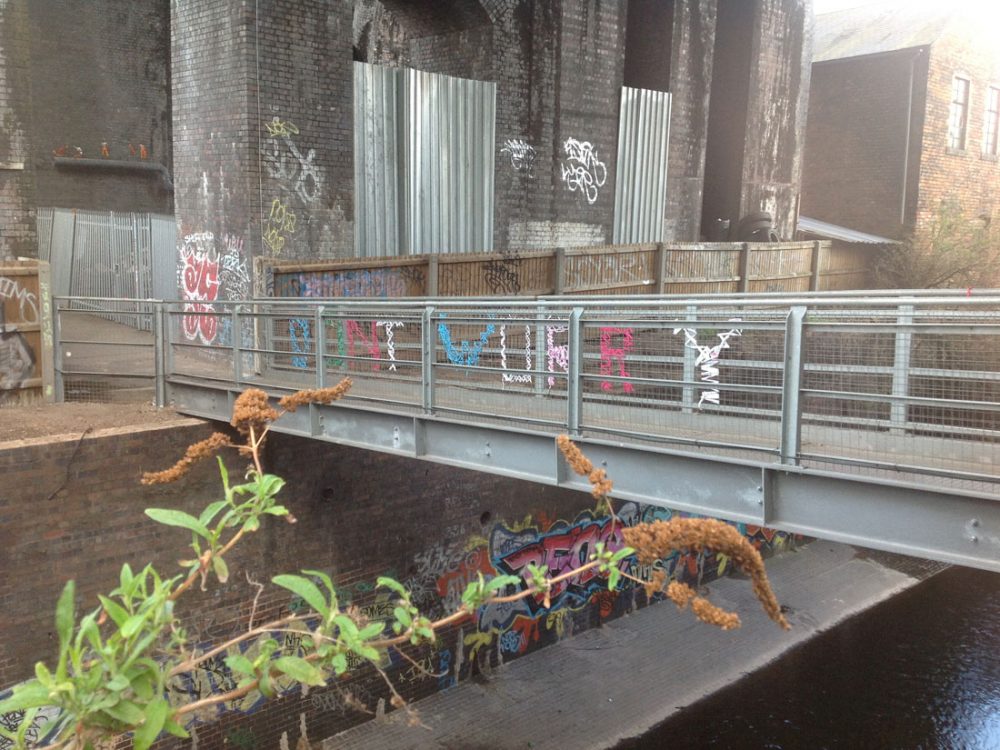 The words 'don't worry' are weaved onto a metal bridge using yarn of various colours.