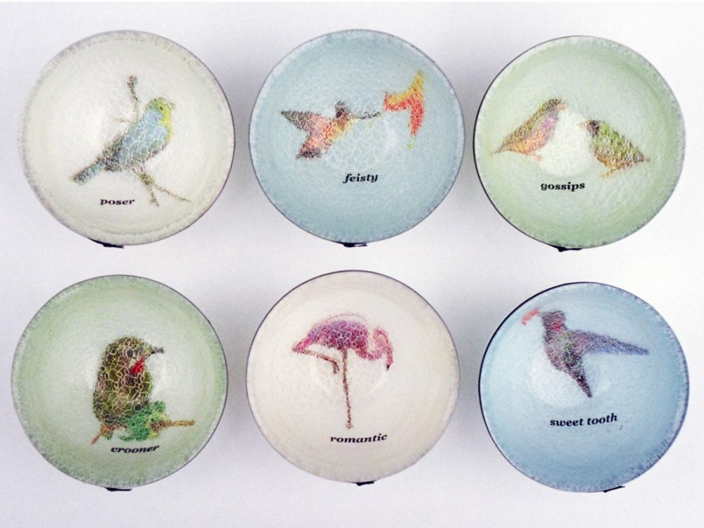 Six bowls with various images of birds inside of them with text underneath of a personality trait including 'romantic'.