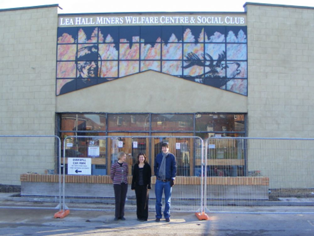 A man and two women stand infront of Lea Hall Miners Welfare Centre and Social Club.