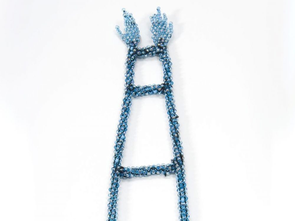 Thread heavily embellished with small blue beads makes the shape of a ladder with hands at the end.