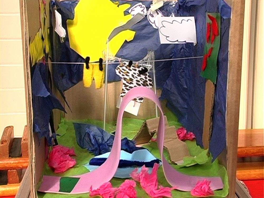 A scene created in a cardboard box using various materials including tissue paper and string.