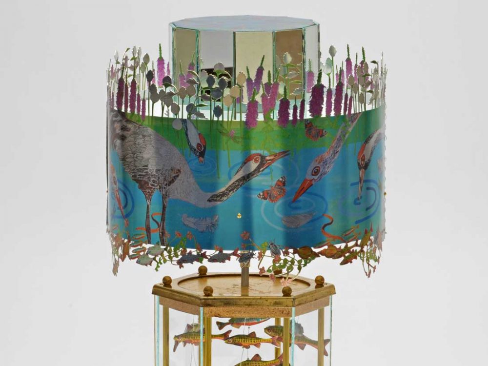 A highly decorated praxinoscope with wildlife scenes including birds, plants and fish.