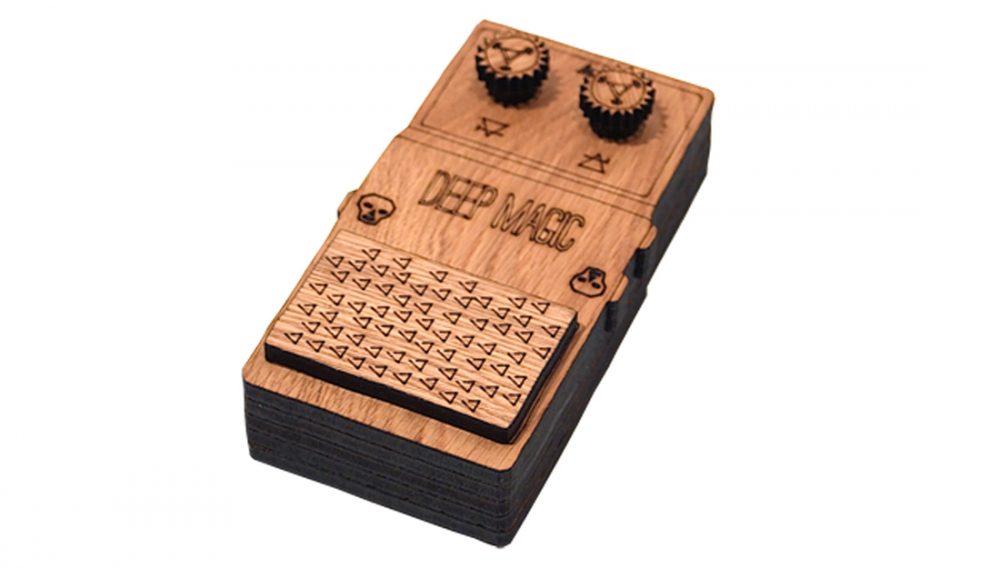 A laser cut model of a guitar pedal showing the words deep magic.