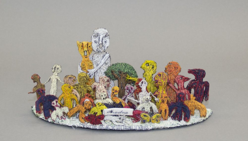 Various figures made from textile and yarn surround a textile tree with the words 'The Gathering' at the front.