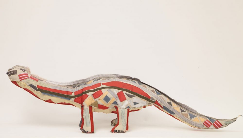A patchwork 3D dinosaur made of various textiles.