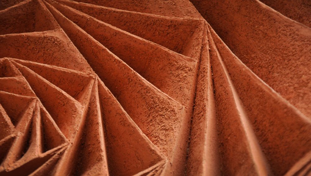 Detail of clay with geometric 3D patterns carved in.