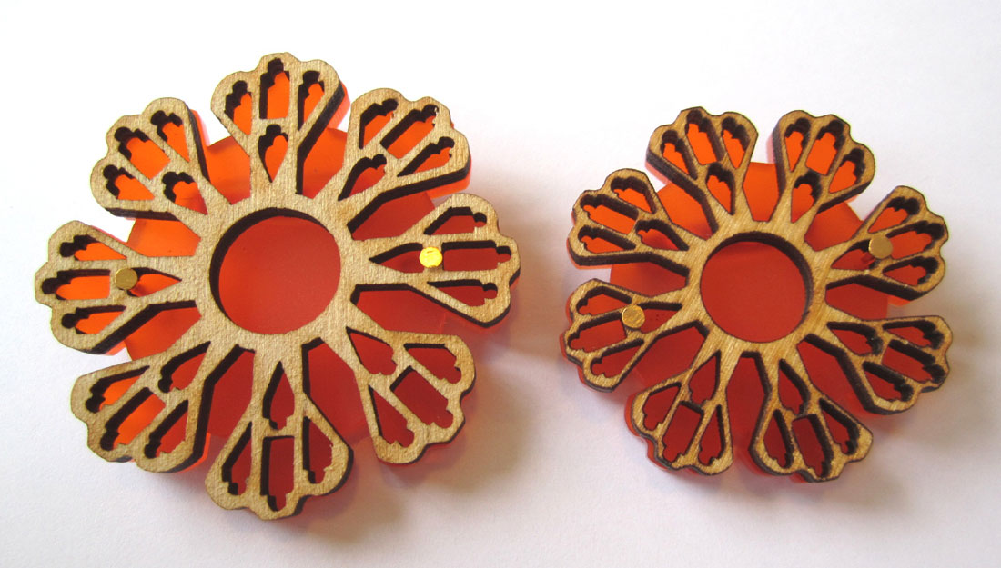 Large and small orange brooches made by Shelanu.