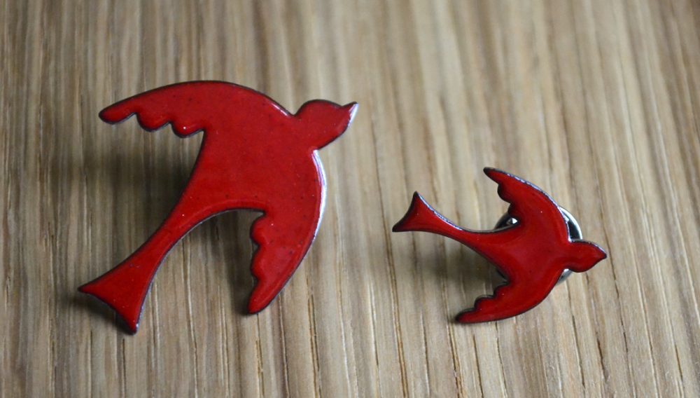 two red enameled bird brooches. simple in design.