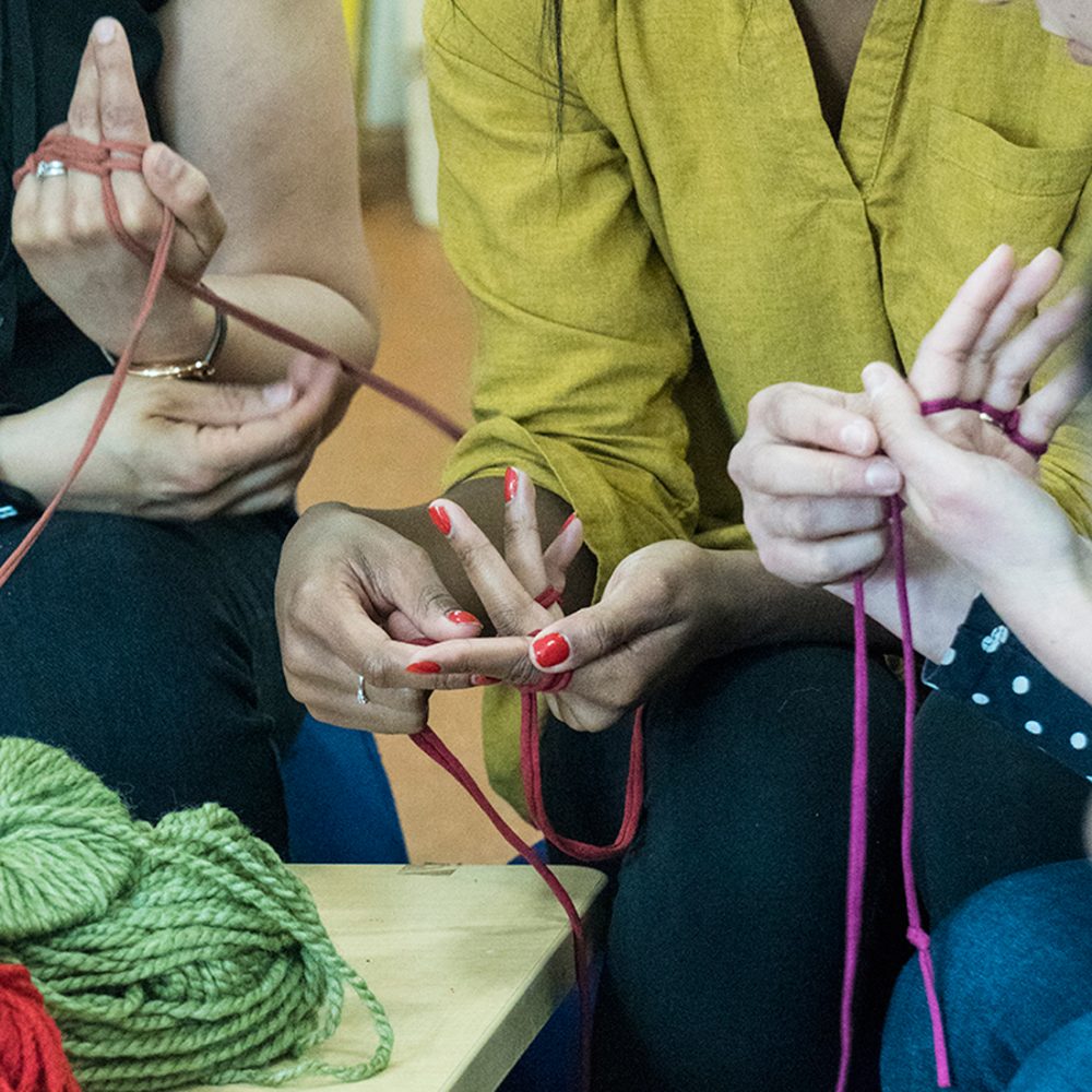 hands and t-shirt yarn. Finger knitting.
