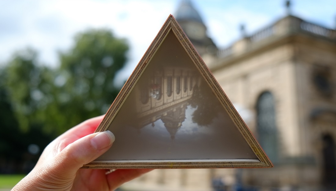 A small hand held camera obscura shows an image of the cathedral.