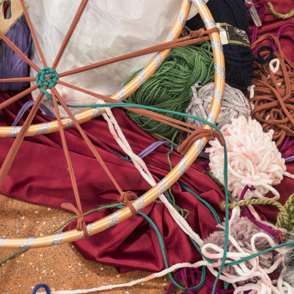 A tangle of coloured wool, hoops, material and tshirt yarn.