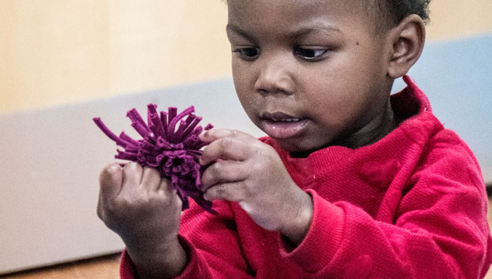 A child interacts with a fabric flower.