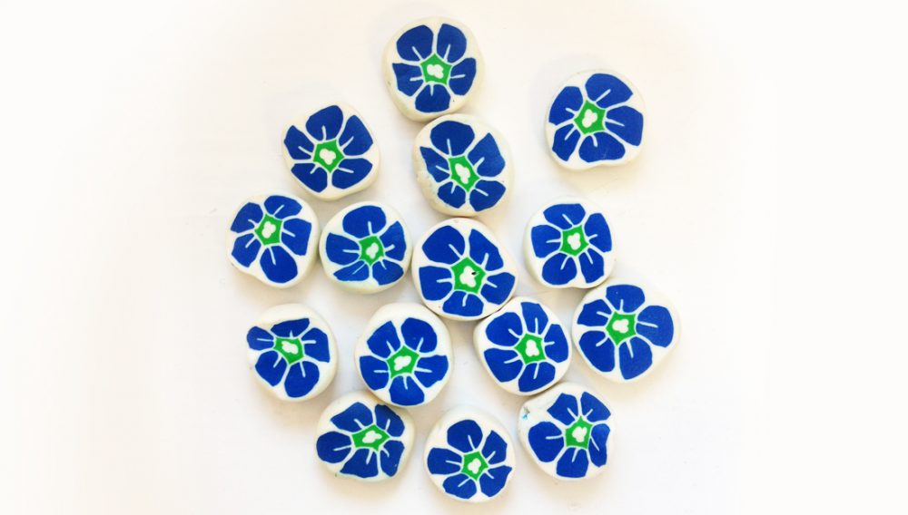 Handmade milliefiori white beads with blue and green flowers.