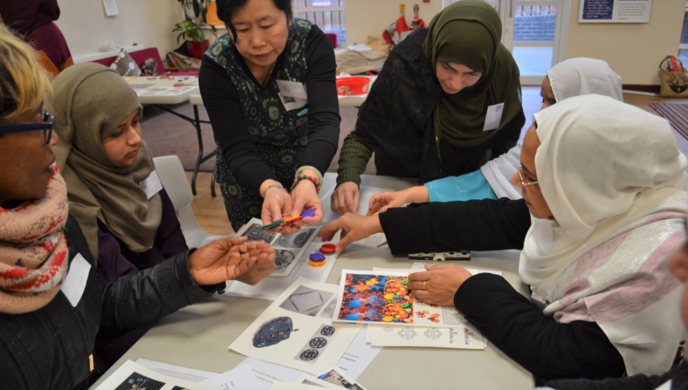 A member of Shelanu helps the group pick the colour and shape of their brooches.