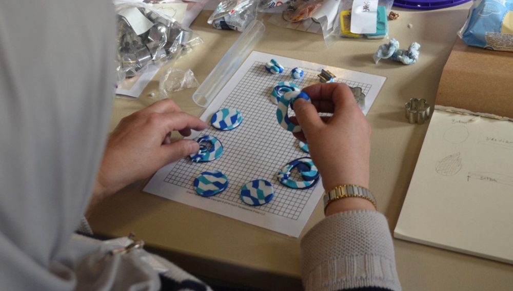 A participant lays out the design for her necklace