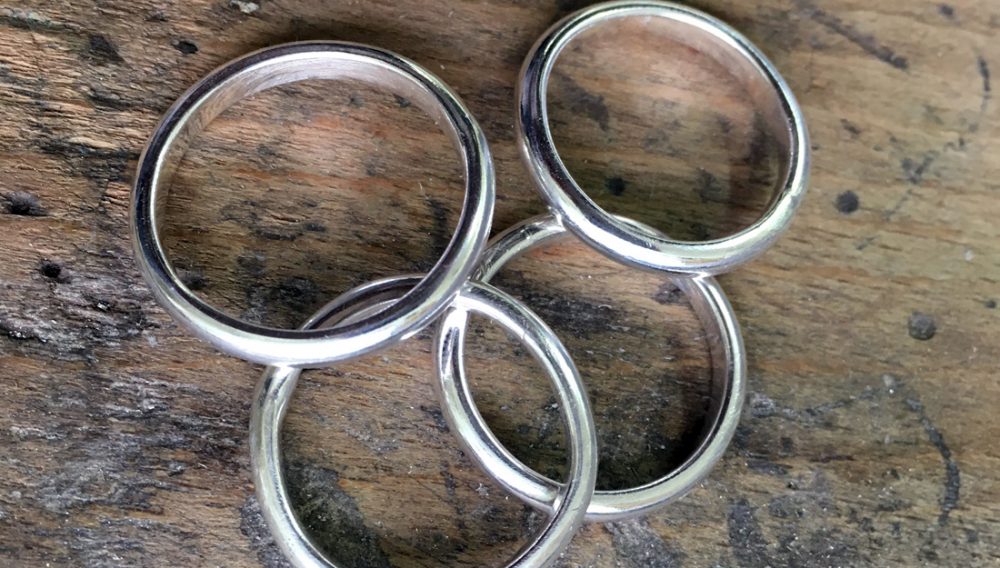 silver rings laying on a table.