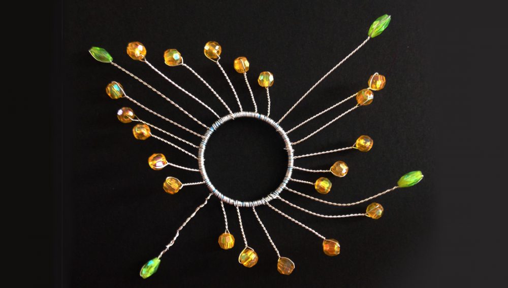 A circle shape made from jewels and wire.
