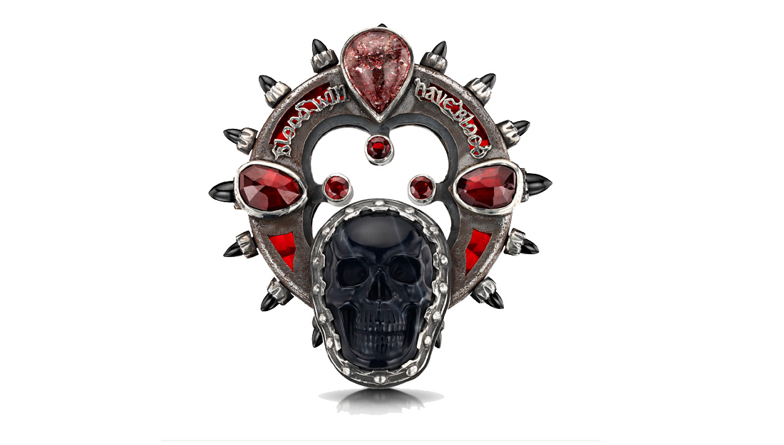 An elaborate brooch featuring a skull and a quote from Macbeth.