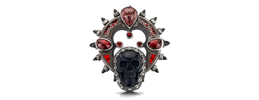 An elaborate brooch featuring a skull and a quote from Macbeth.