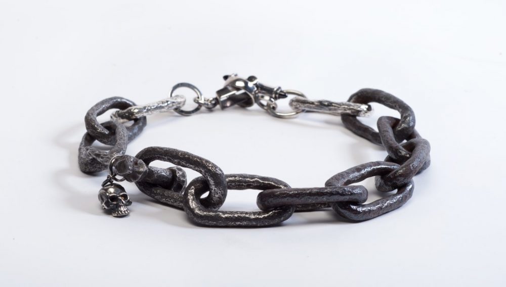 A bracelet featuring chain links and a small skull charm.
