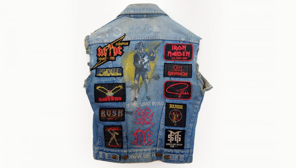 a well worn denim jacket with patches from heavy metal gigs.
