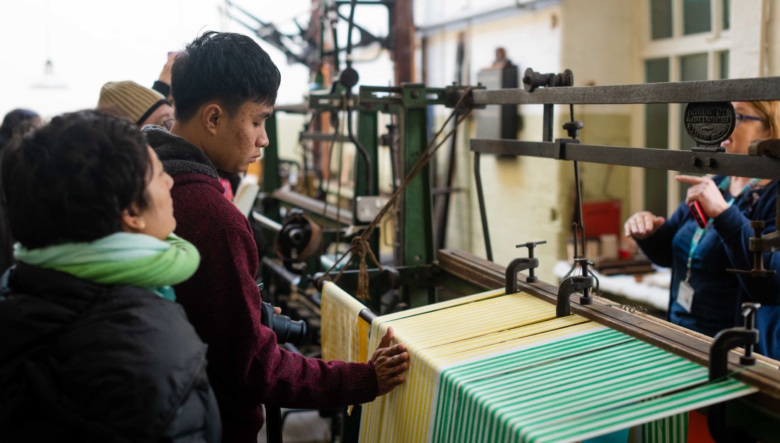 Delegates looking at an old-fashioned weaving loom