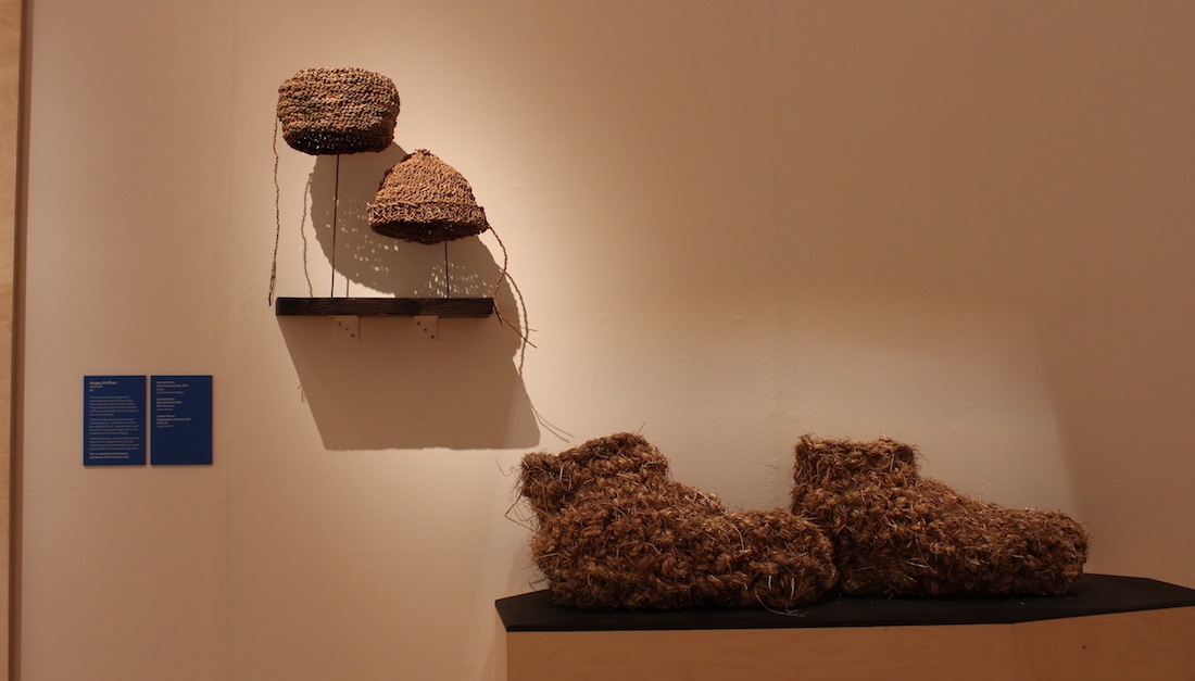 woven hats and large woven boots on plinth