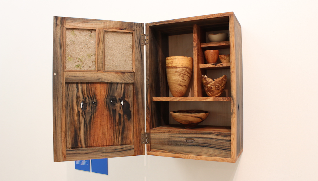 wooden cupboard on shelves with wood turned items inside
