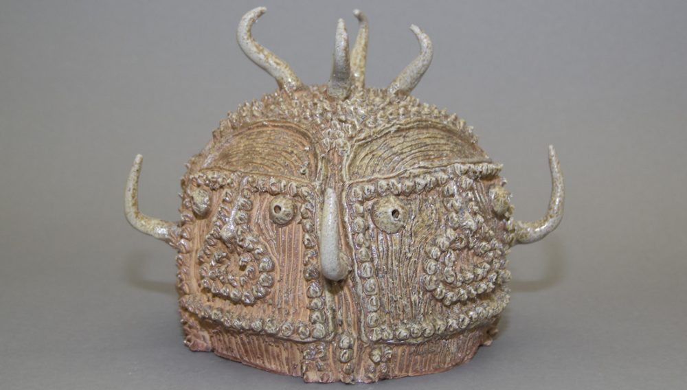 ceramic sculpture with two faces and horns