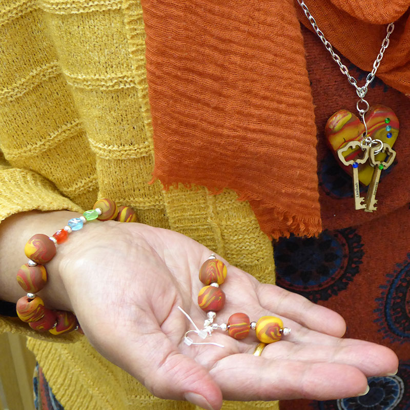 a woman wears the jewellery she has made