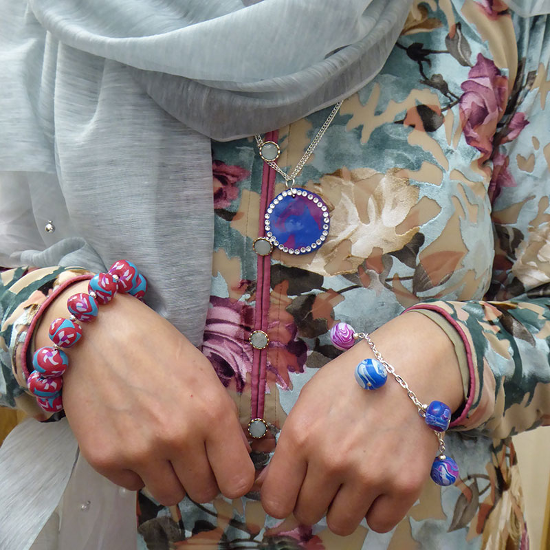 a woman wears the jewellery she had made.