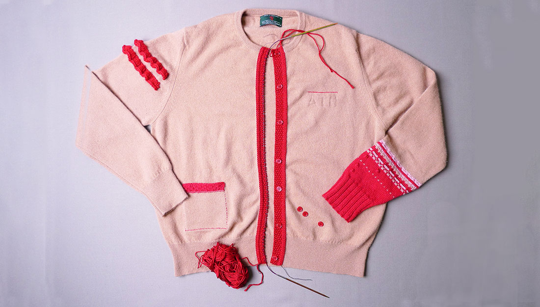 A pink cardigan which has sections that have been re-knitted.