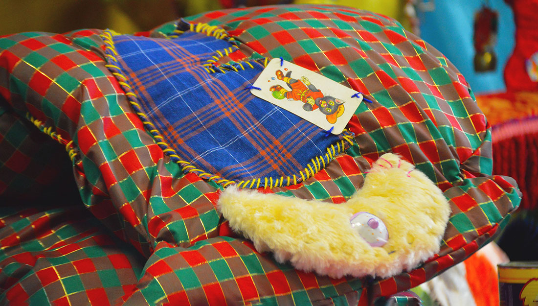 a soft tartan covered textile sculpture with appliqued playing card and sheepskin.