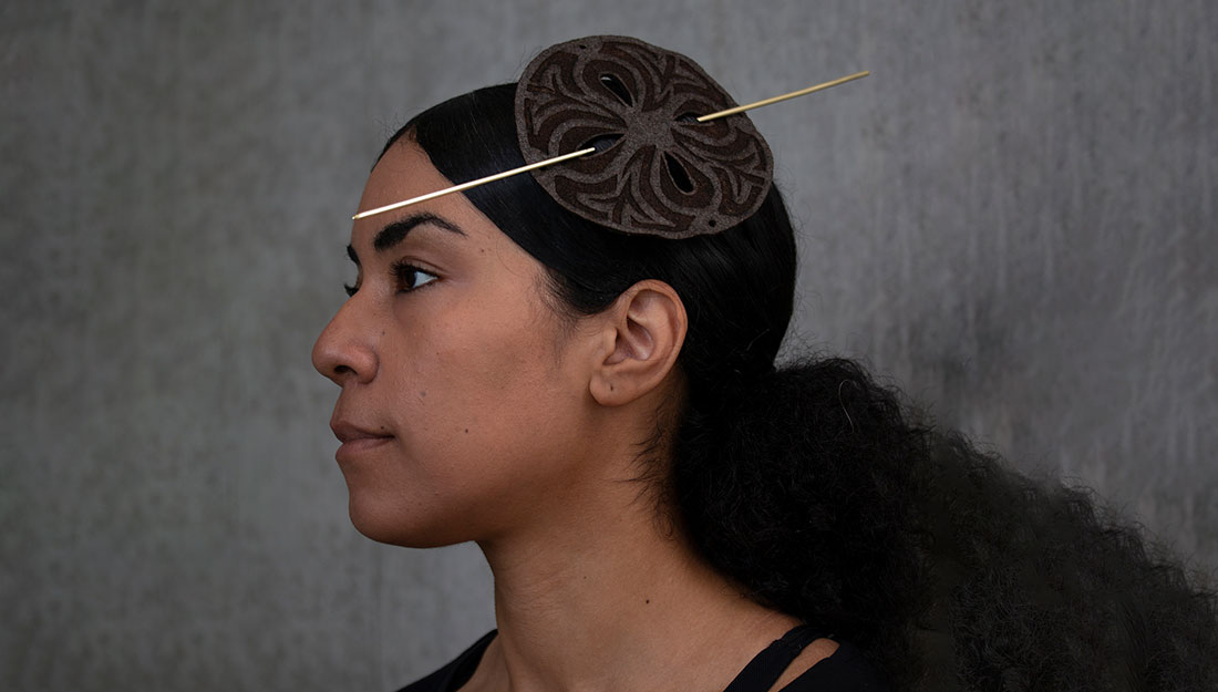 A woman wears a headpiece.