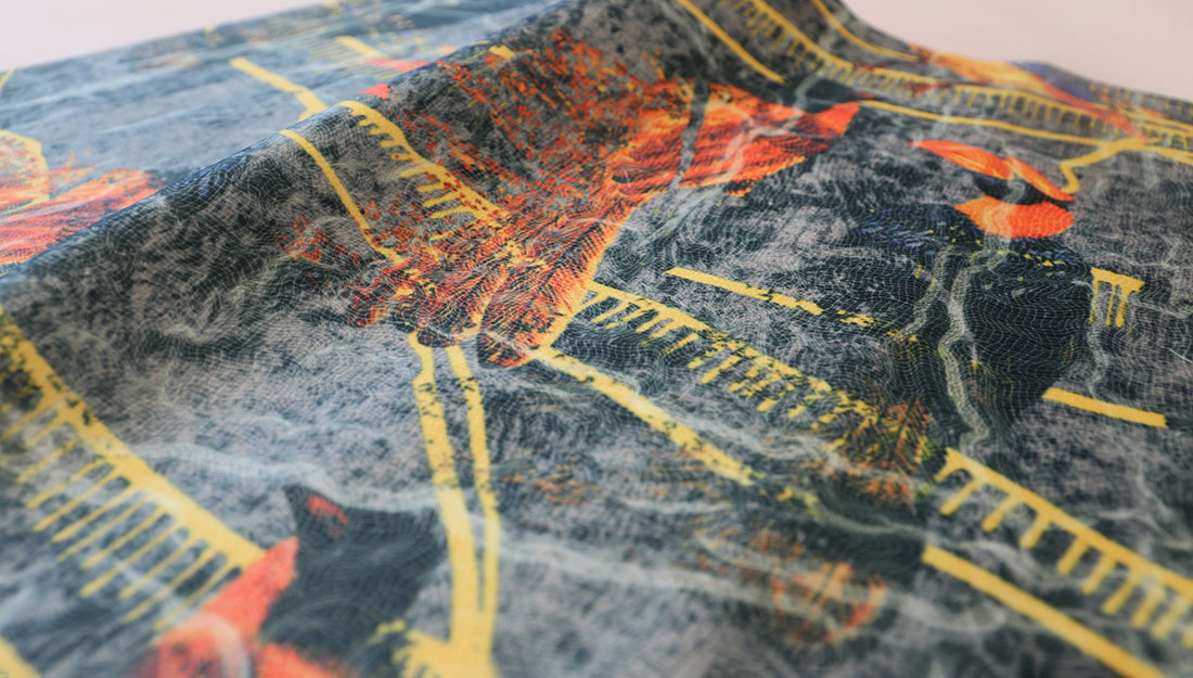 A cloth printed with a pattern of birds and trees.