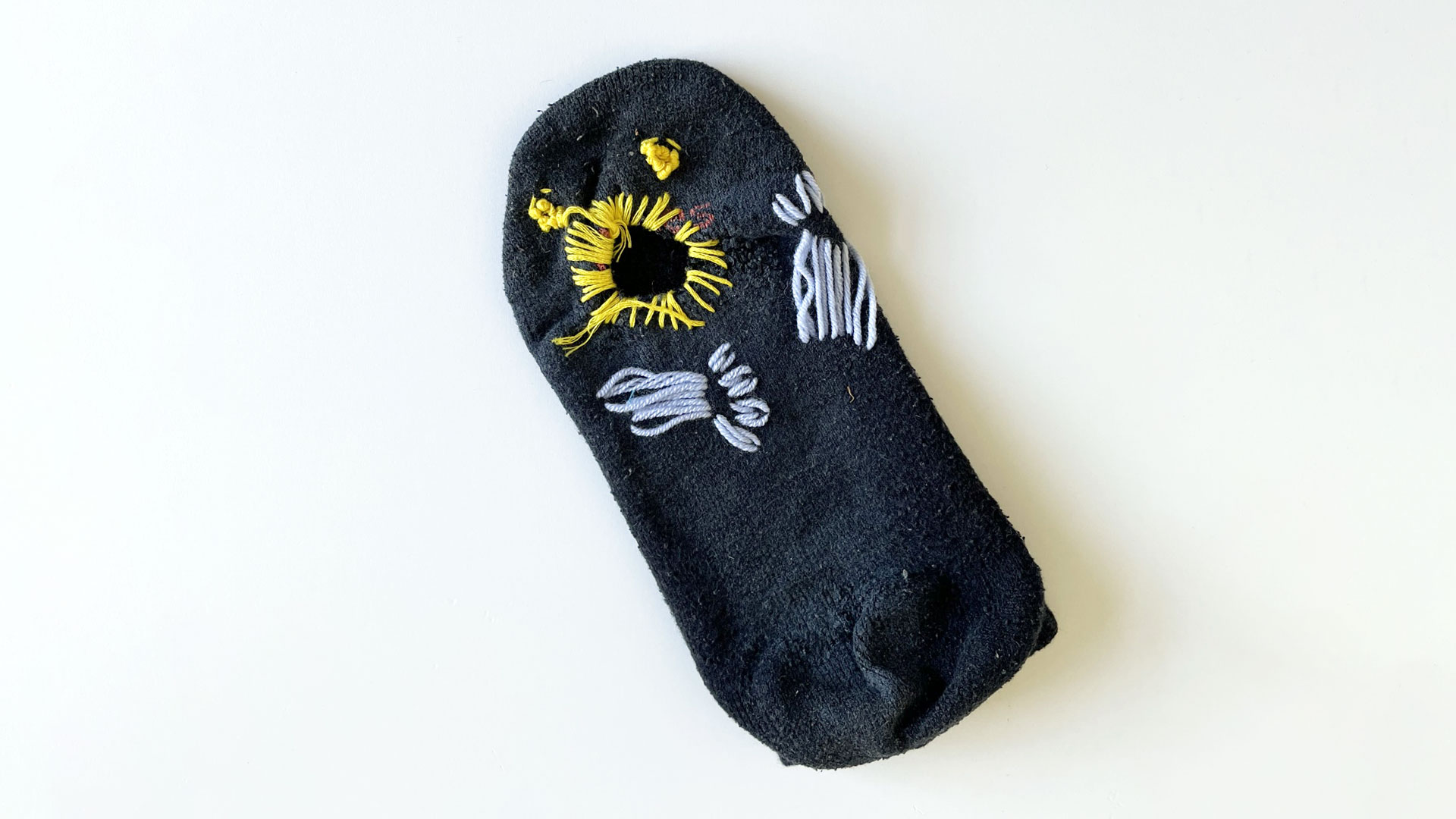A black sock with yellow and blue embroidery decoration
