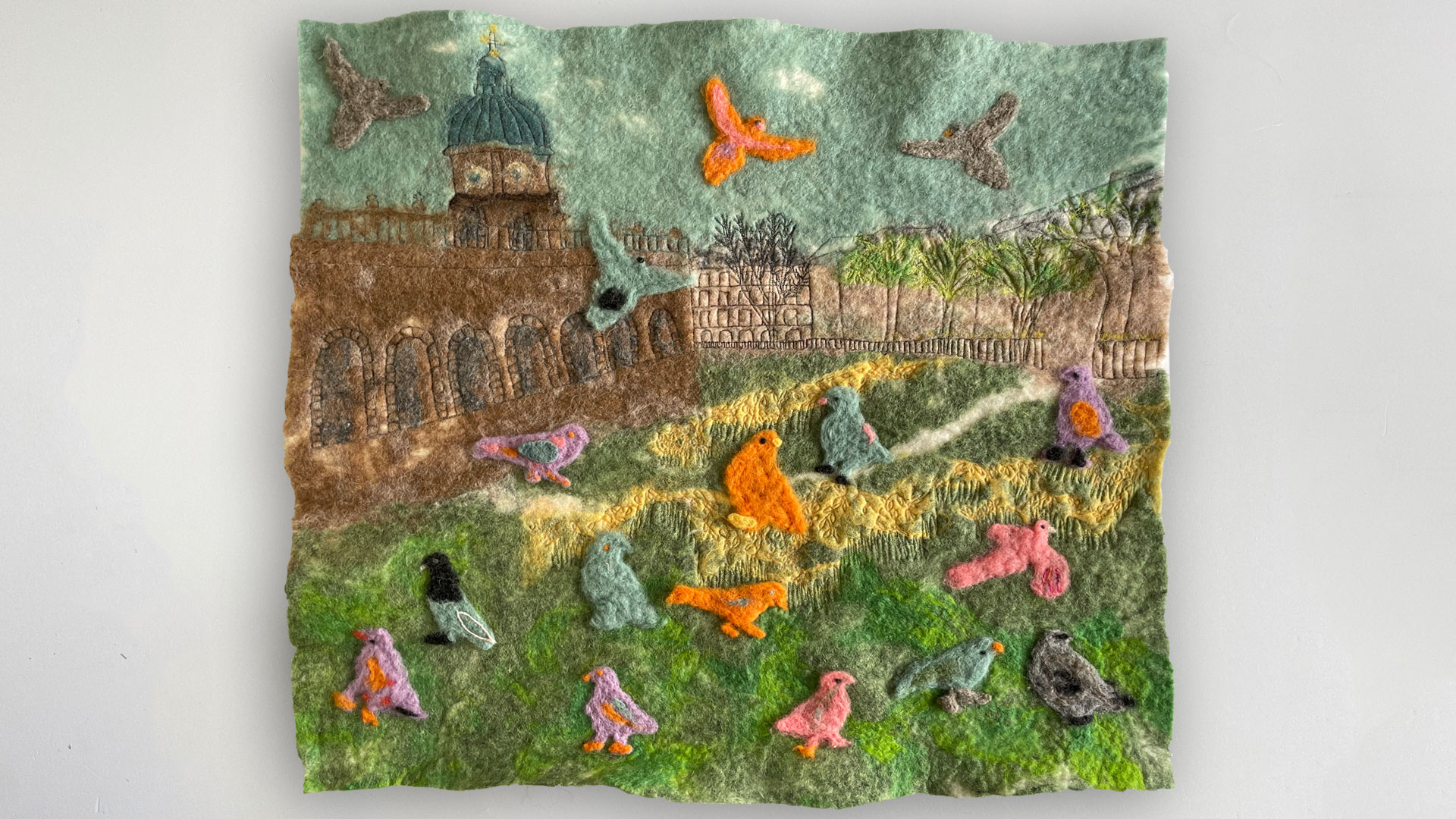 A large colourful square felt scene with many felt birds