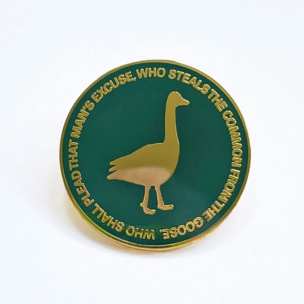 A green enamel badge with a golden goose icon.