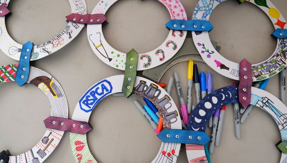 cardboard circles are decorated with bright pens and fixed together like chainmail.