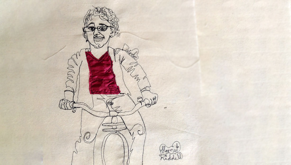 A portrait of Deirdre riding the bike that powers the sewing machine which stitches the portrait.