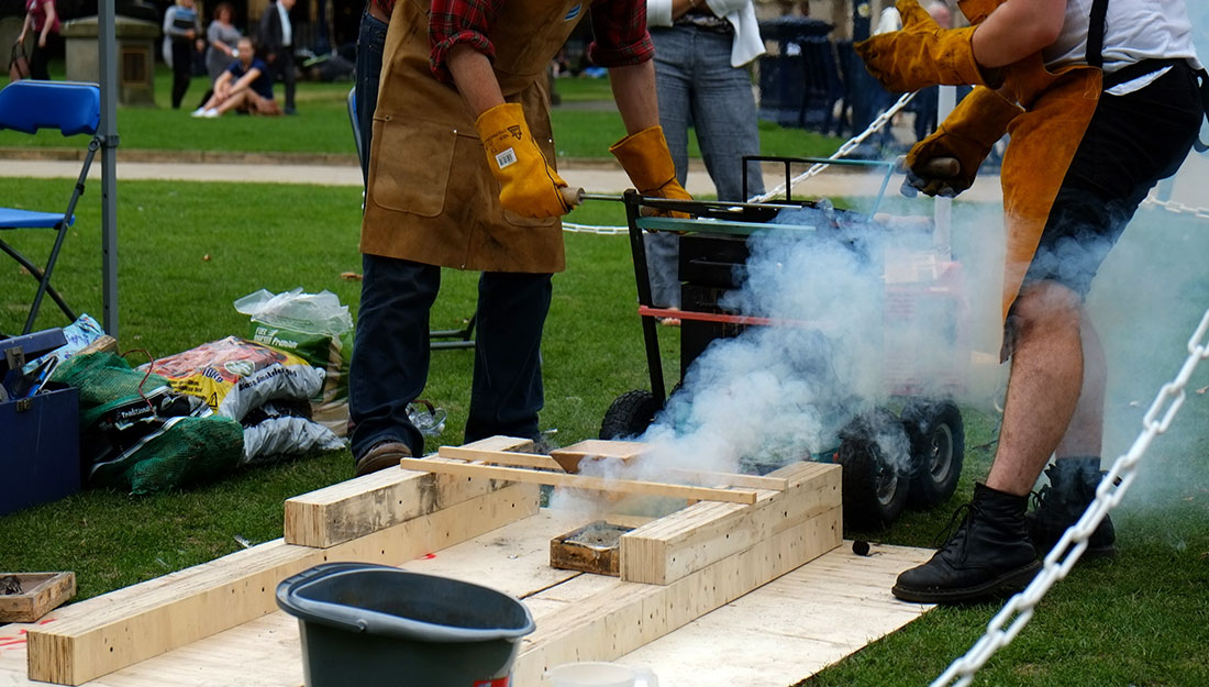 Steam rises from a cast piece of aluminium in a mould.